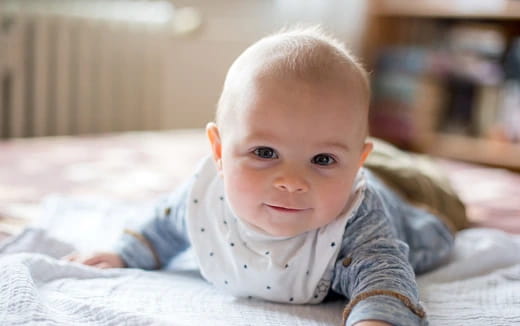 a baby lying on a bed