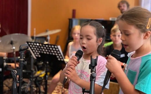 a group of kids singing into microphones