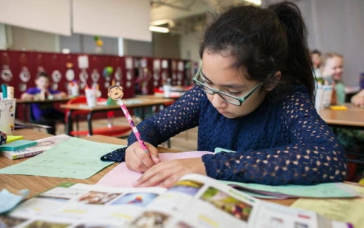 a young girl coloring on a book