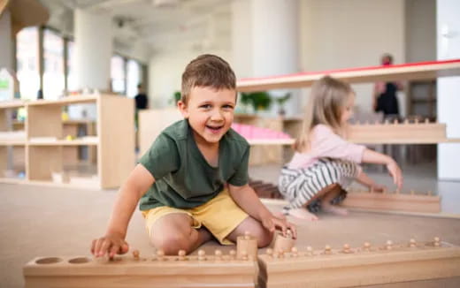 a boy and a girl playing on a wooden floor