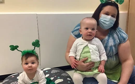 a person and two babies wearing face masks