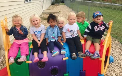 a group of children sitting on a toy train