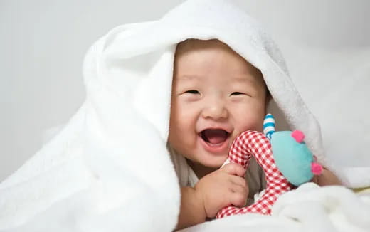 a baby with a white blanket