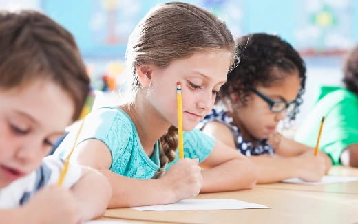 a group of children writing on paper