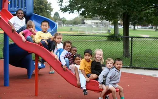 a group of children sitting on a playground slide