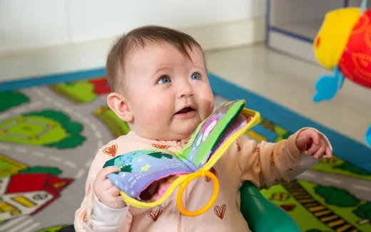 a baby in a highchair holding a toy