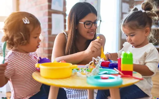 a woman and two children playing with toys