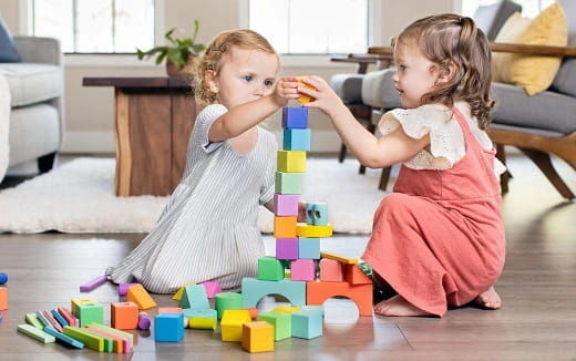 a person and a child playing with toys on the floor