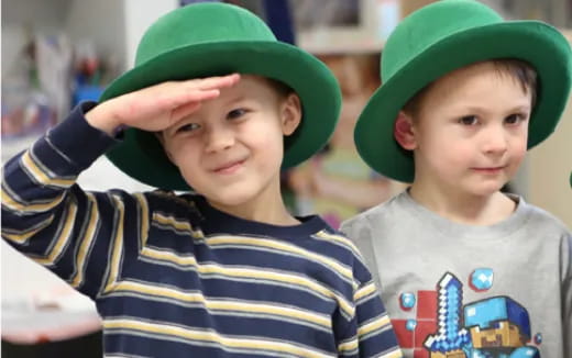 a couple of boys wearing green hats