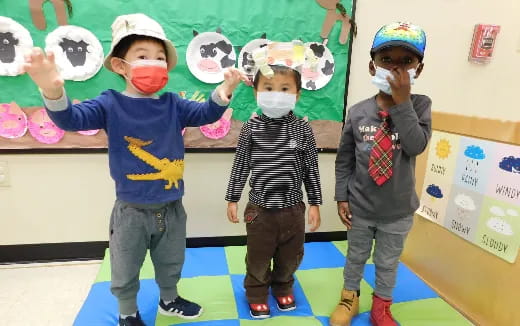 a group of kids wearing masks and holding up paper faces