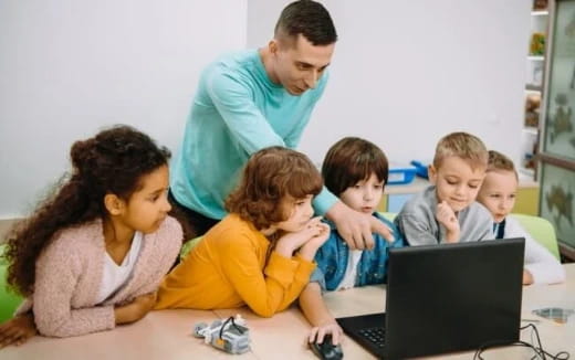 a man and woman with children looking at a laptop