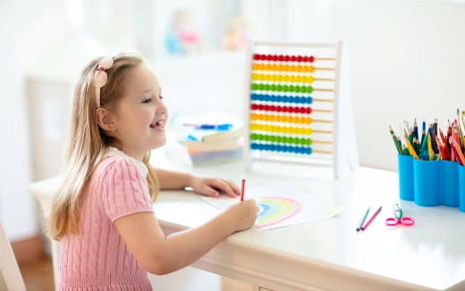 a girl coloring on a paper