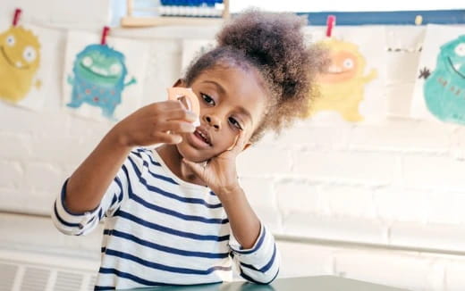 a child with a hand on her face