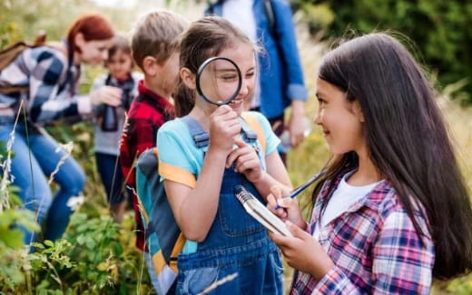 a group of children looking at a cell phone