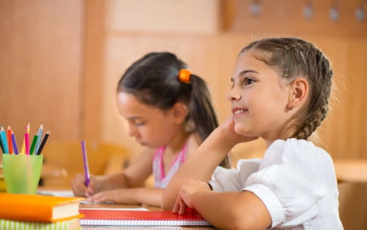 a young girl and a young girl sitting at a desk