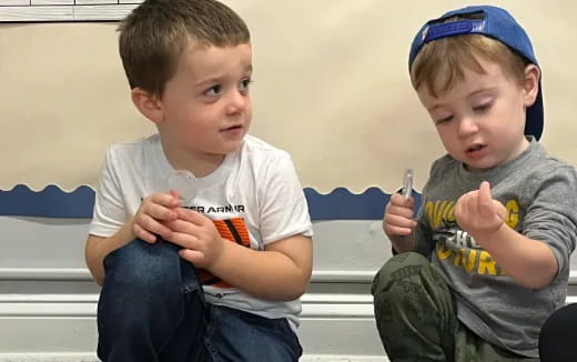 two boys sitting on a bench