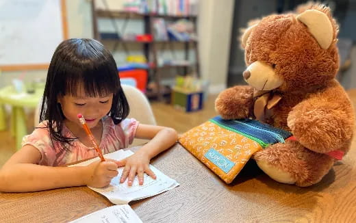 a young girl writing on a book