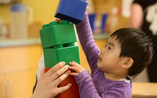 a child holding a green toy