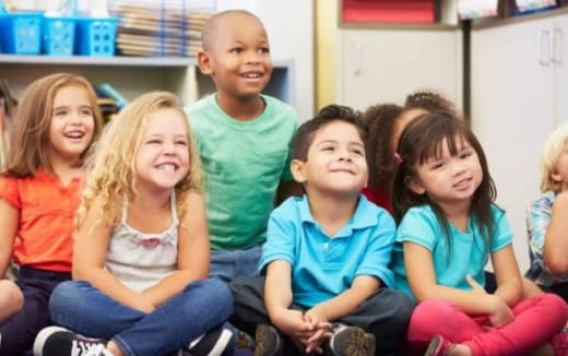 a group of children sitting in a classroom