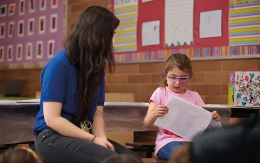 a person and a girl looking at a paper