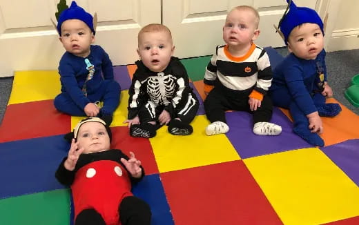 a group of babies sitting on a rug