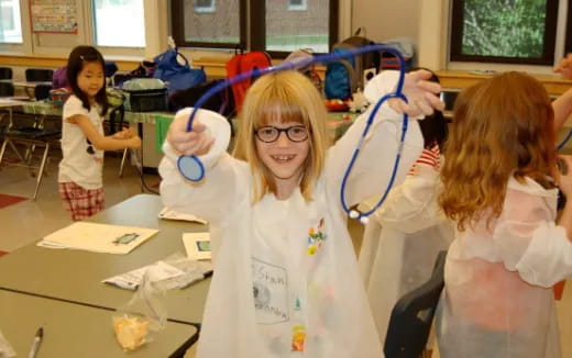 a group of children wearing white lab coats and blue headphones