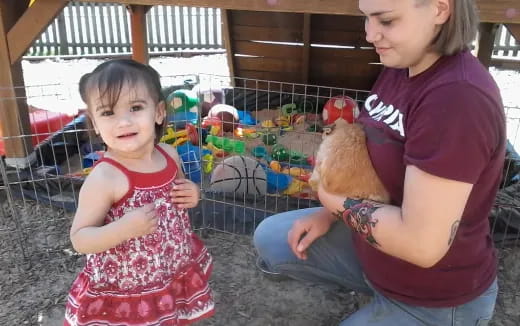 a person and a child holding a chicken