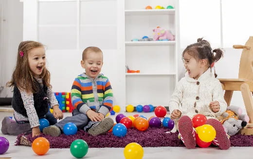a group of children sitting on the floor with balls
