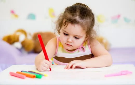 a baby girl coloring on a paper