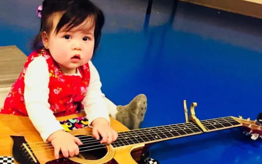 a baby playing a guitar