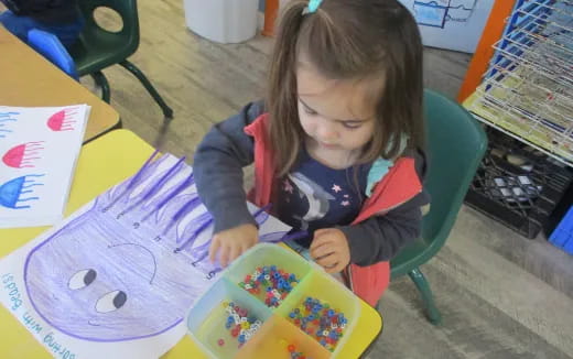 a girl coloring on a paper