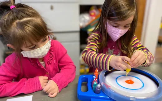 a couple of young girls playing with a toy