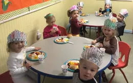 a group of children eating at a table