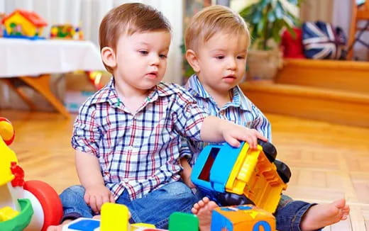 two boys sitting on a toy