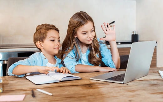 a boy and girl looking at a laptop