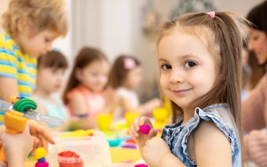 a young girl holding a toy