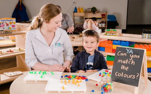 a person and a boy sitting at a table with a cake