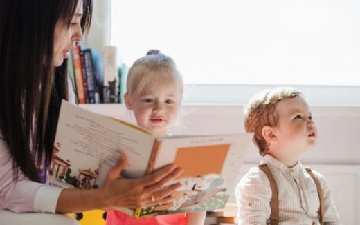 a person reading a book to a young boy