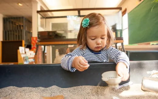 a little girl sitting at a table