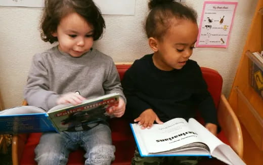 a couple of children reading a book