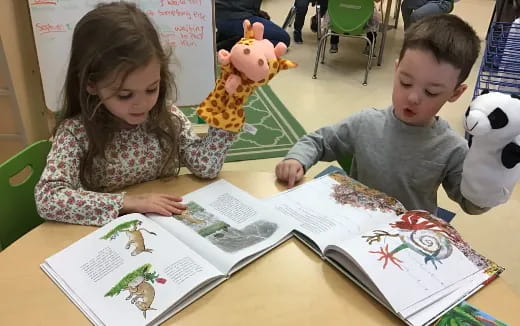 a boy and girl looking at a book