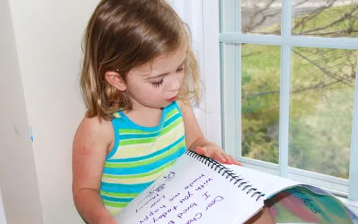a girl writing on a piece of paper