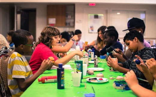 a group of people sitting around a table with food and drinks