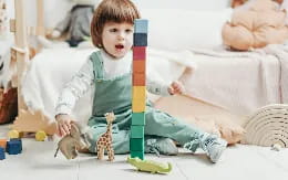 a child sitting on the floor with a toy sword