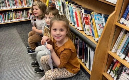 a group of children sitting in a library