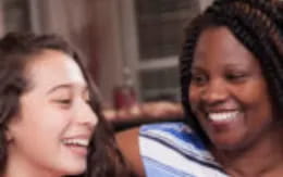 a person smiling next to another woman