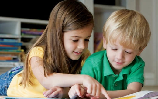 a person and a boy looking at a book