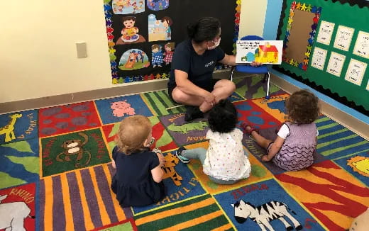 a person and several children sitting on the floor