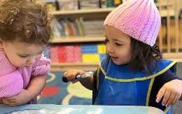 a young girl and a young girl looking at a cell phone