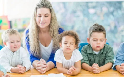 a person and several children sitting at a table